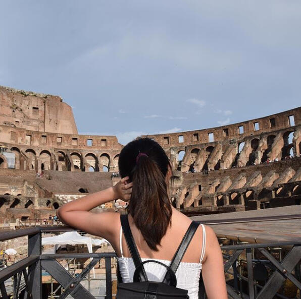 Girl with her back facing the camera, with the Colosseum as backdrop.